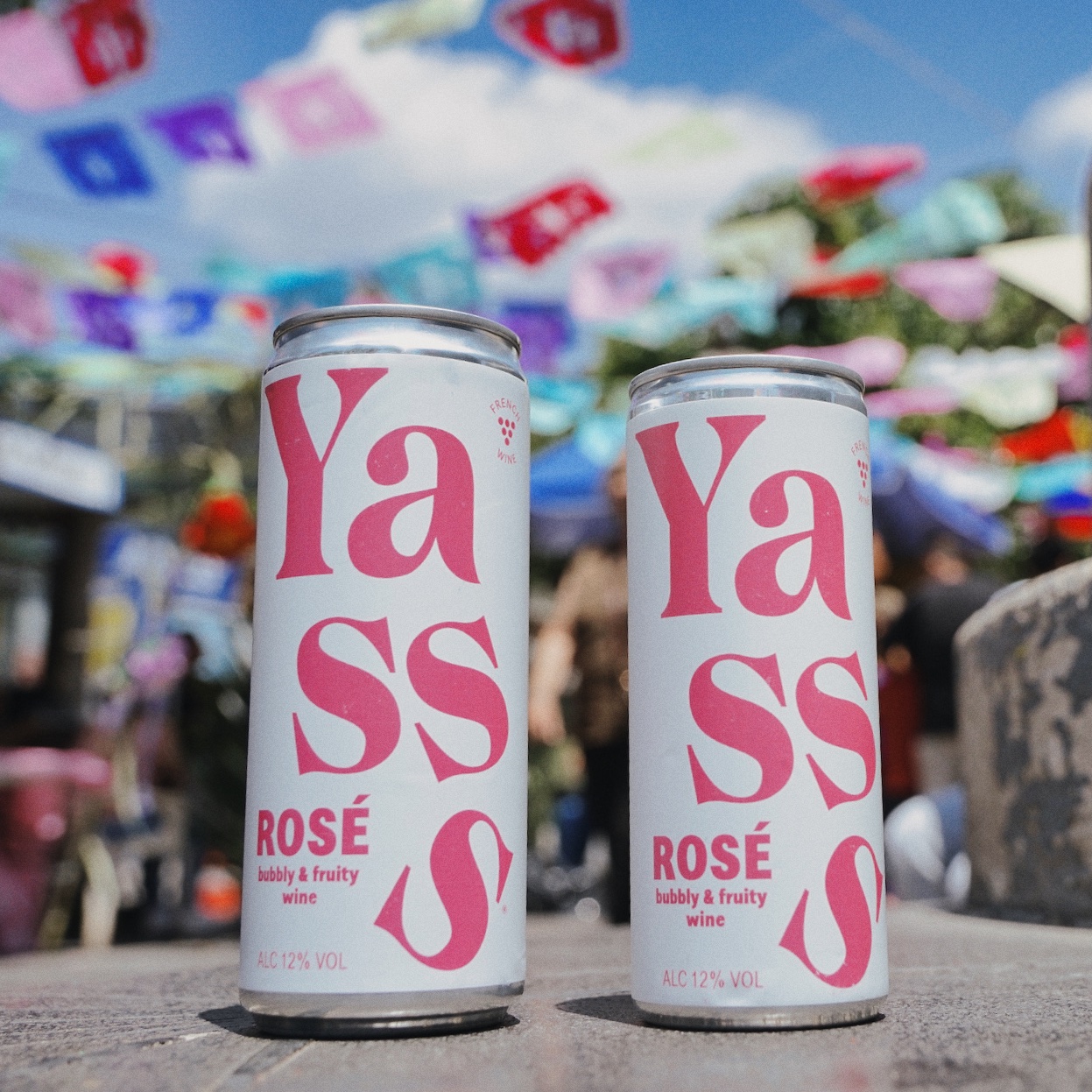 Yasss Rosé 250ml and Yasss Rosé 330ml on a colorful outdoor background